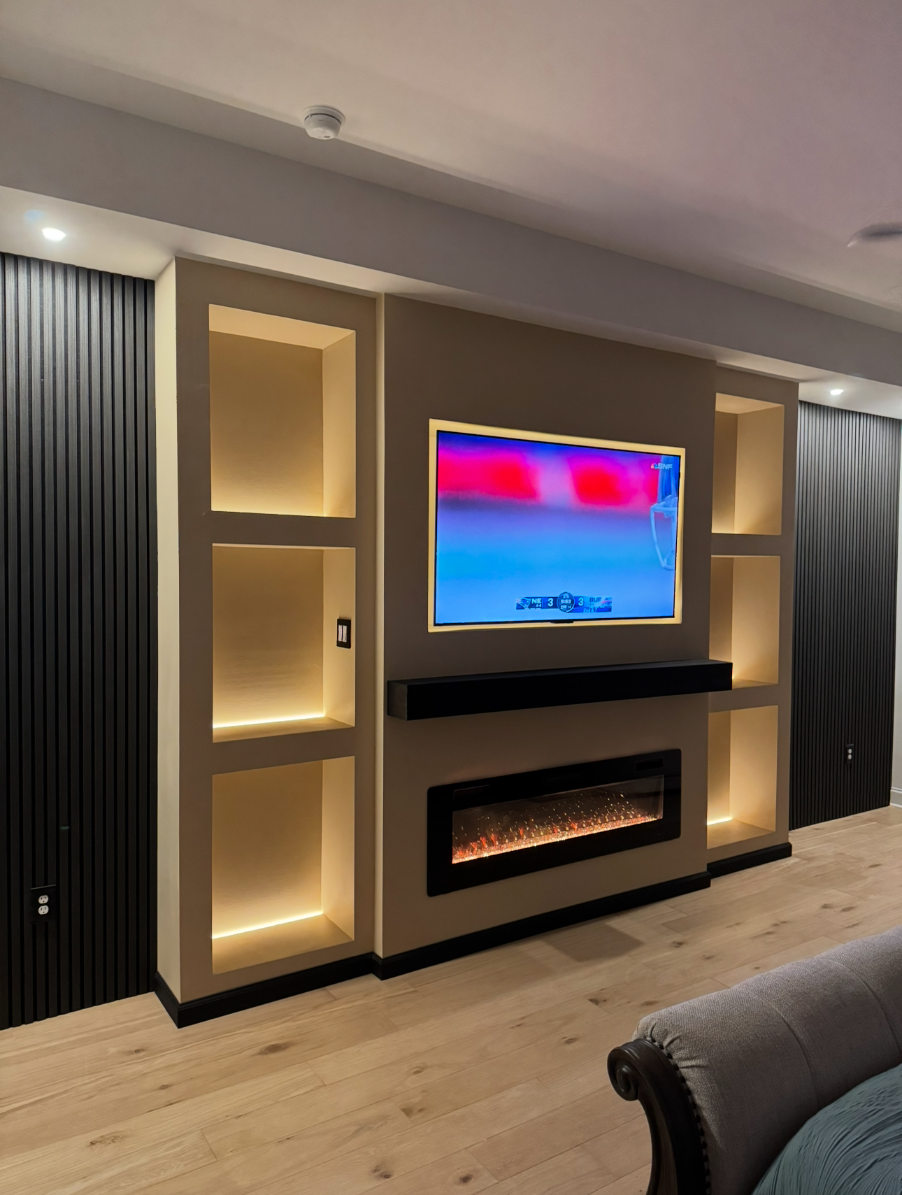 Media wall with vertical black slat panels and central fireplace