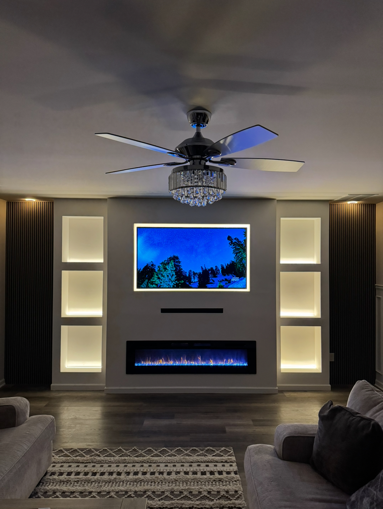 Custom media wall with fireplace and six illuminated shelving nooks
